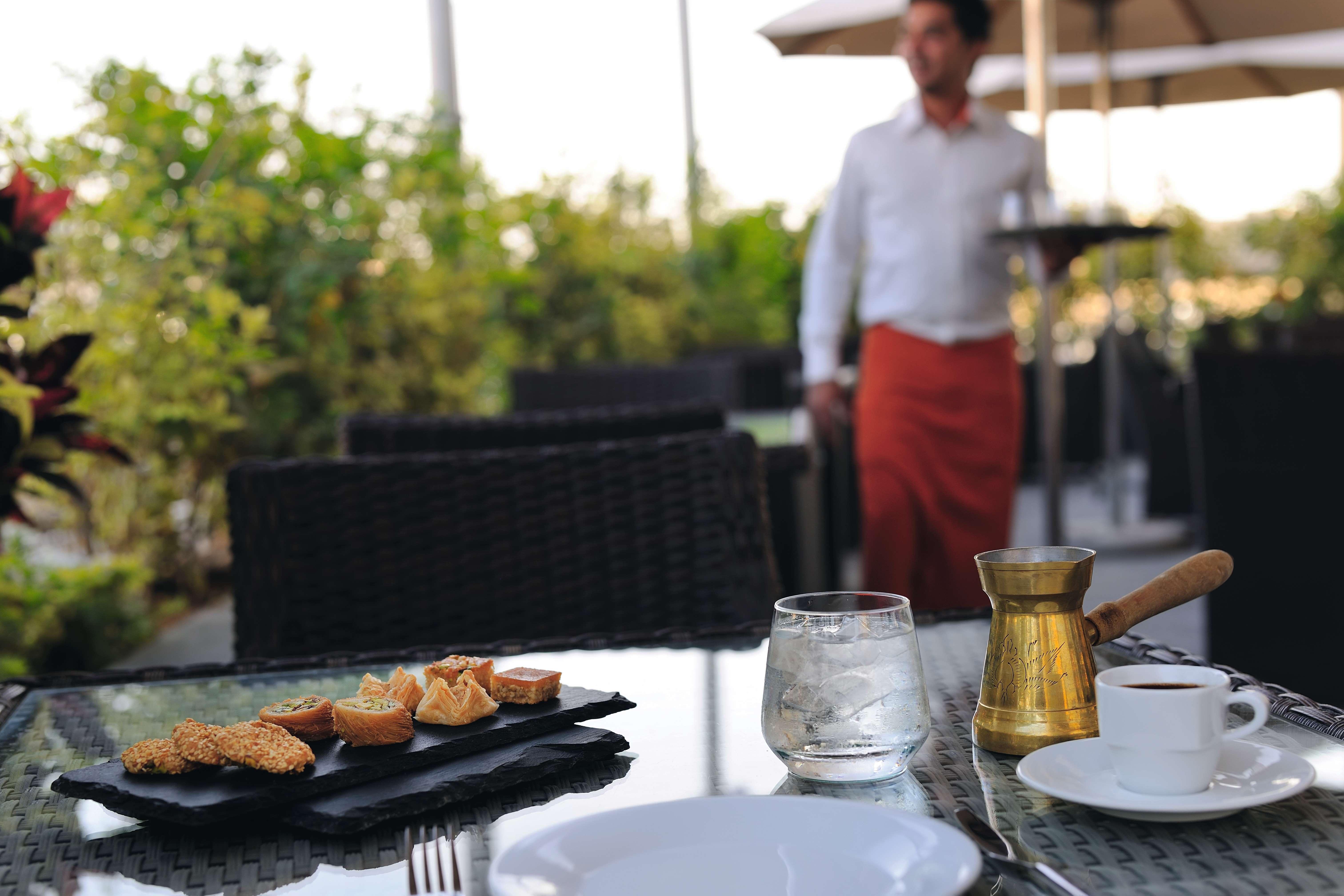 Mövenpick Hotel Apartments Al Mamzar Dubai Exterior foto A waiter at work